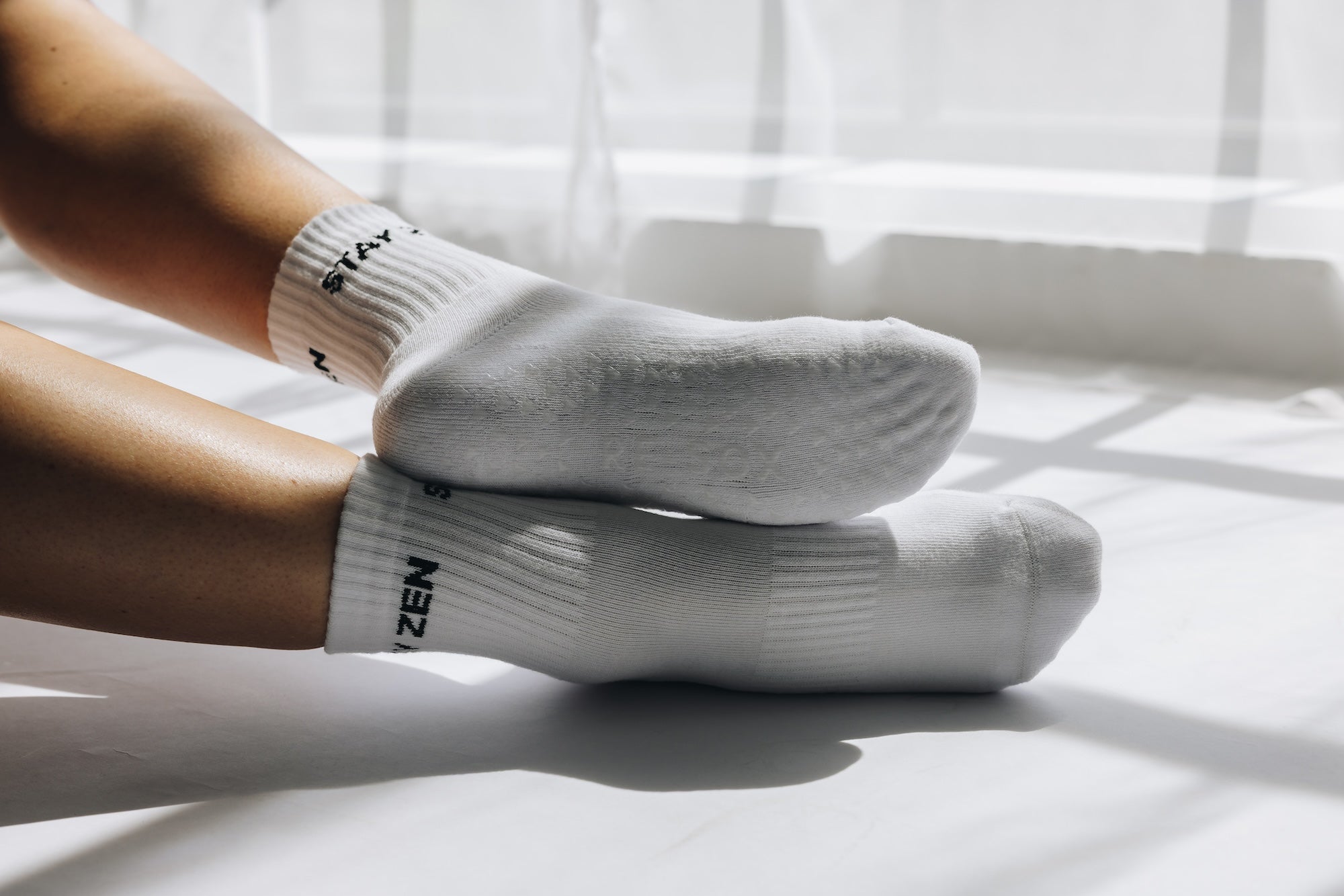 White grip socks with black text stay zen on a white surface