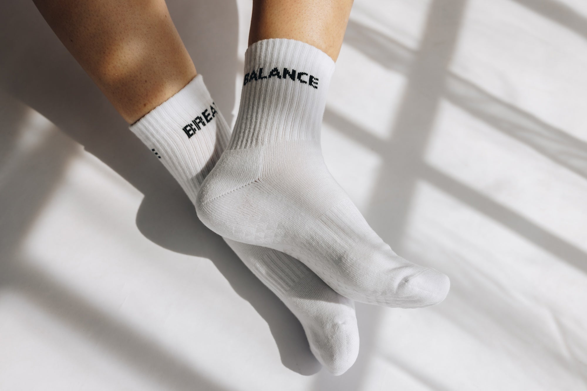 White grip socks with text balance/breathe on a light background