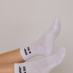White  grip socks with 'Grip & Go' text on a neutral background