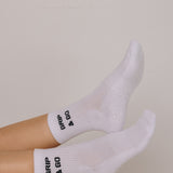 White  grip socks with 'Grip & Go' text on a neutral background