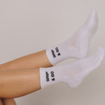 White grip socks with 'Grip & Go' branding on a neutral background