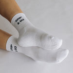 White grip socks with 'GRIP & GO' branding on a light gray background