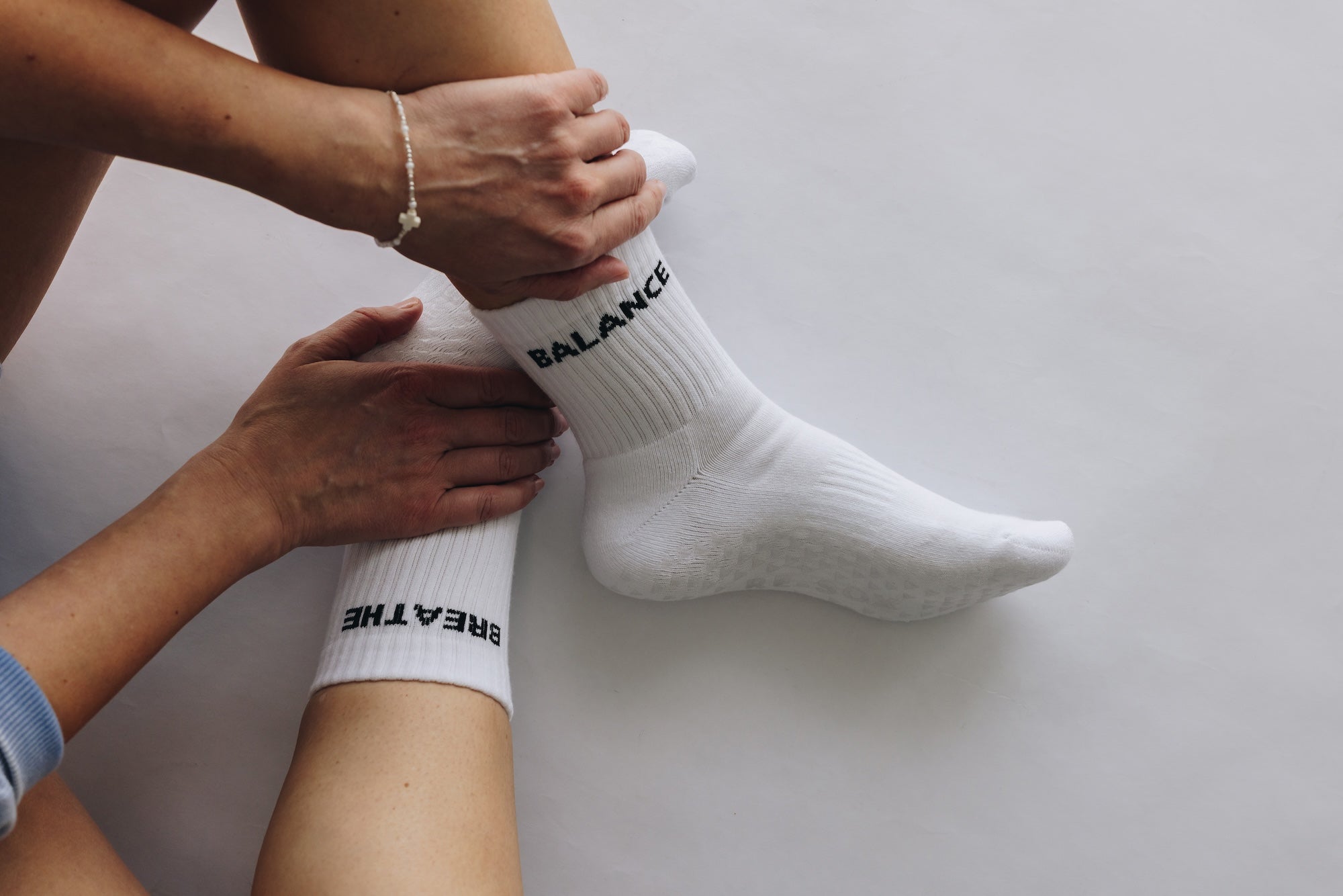 White grip socks with text being worn on a plain background