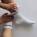White grip socks with text being worn on a plain background
