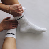 White grip socks with text being worn on a plain background