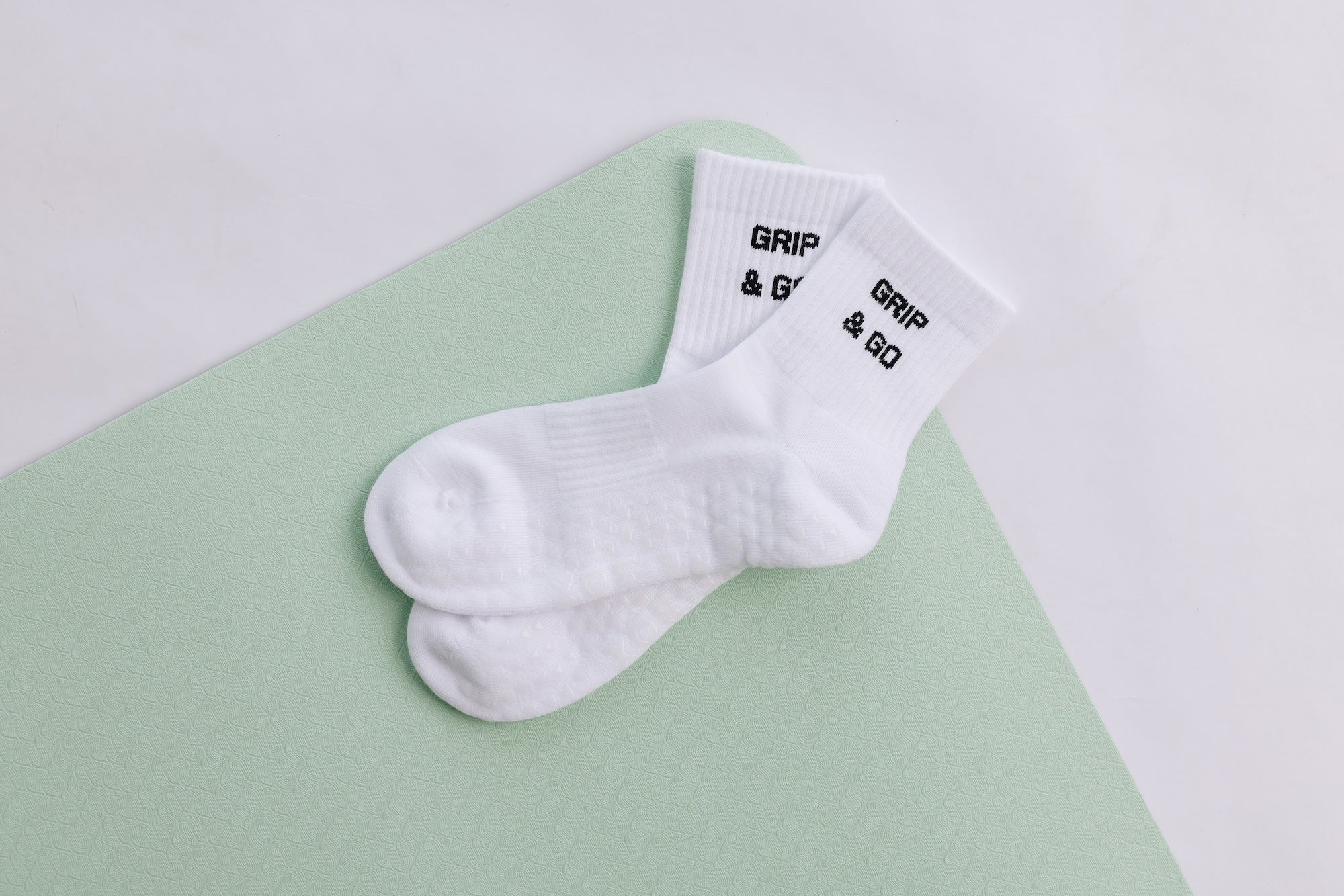 White grip sock with 'Grip & Go' branding on a light green and white background