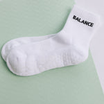 White grip sock with 'BALANCE' text on a light green background
