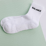 White grip sock with 'BALANCE' text on a light green background