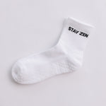 White grip sock with 'STAY ZEN' text on a light gray background