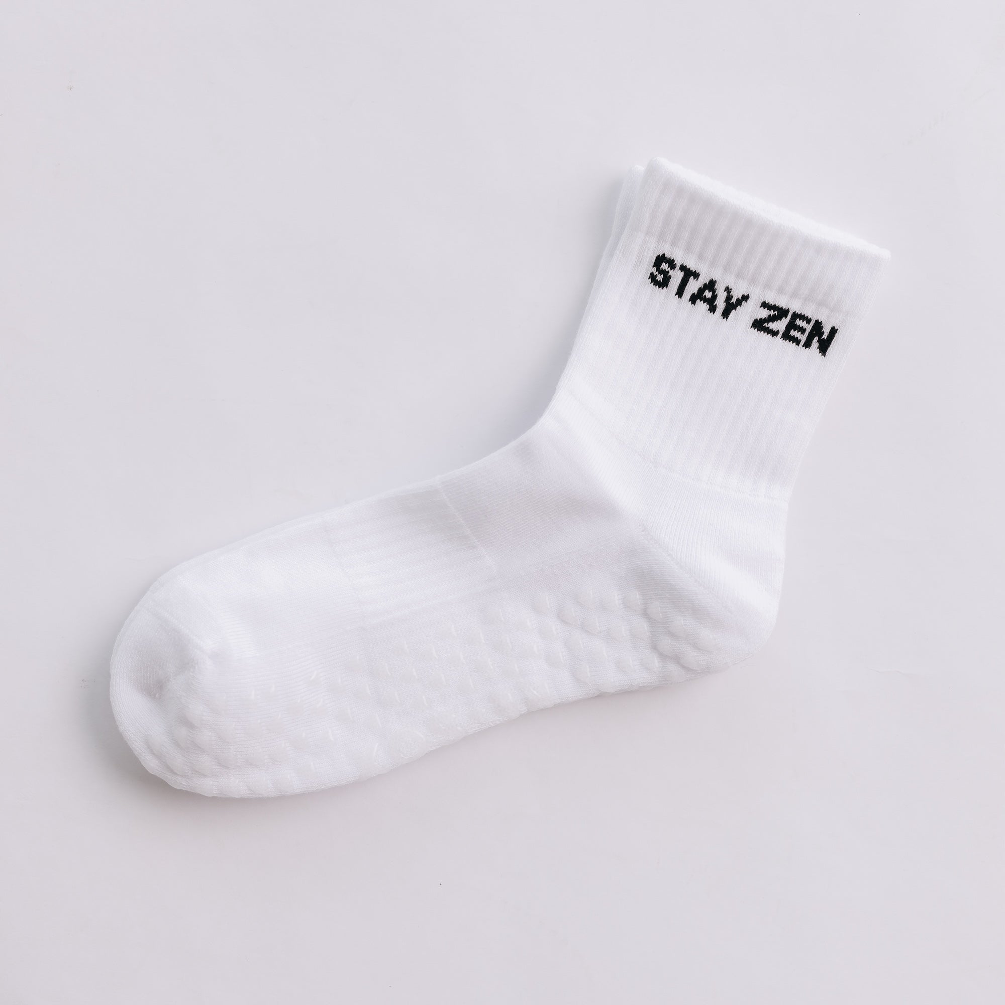 White grip sock with 'STAY ZEN' text on a light gray background