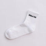 White grip sock with 'BREATHE' text on a light gray background
