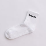 White grip sock with 'BREATHE' text on a light gray background