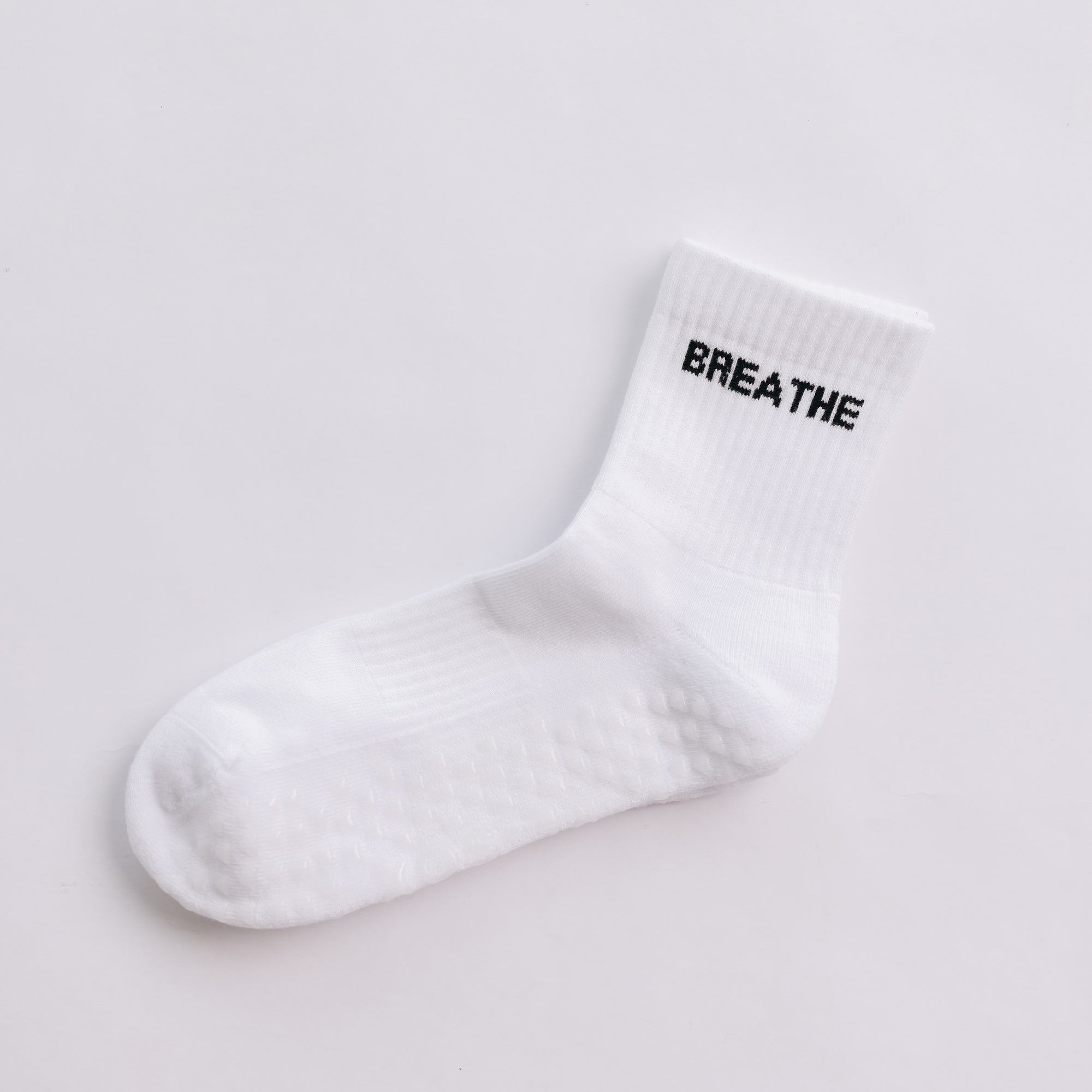 White grip sock with 'BREATHE' text on a light gray background