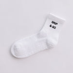 White  grip sock with 'Grip & Go' text on a light gray background
