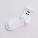White  grip sock with 'Grip & Go' text on a light gray background